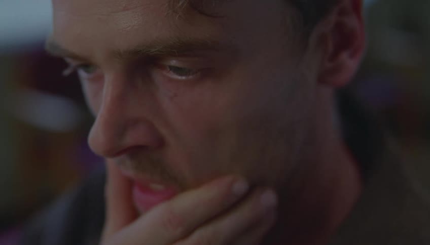 Young adult man with a sad facial expression passing his hand over his face