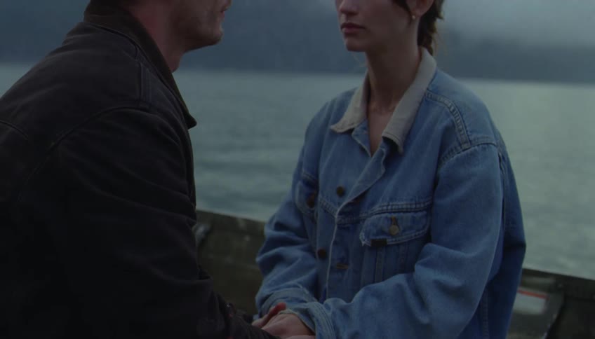 Couple sharing a quiet emotional support while drifting on a calm lake at sunset