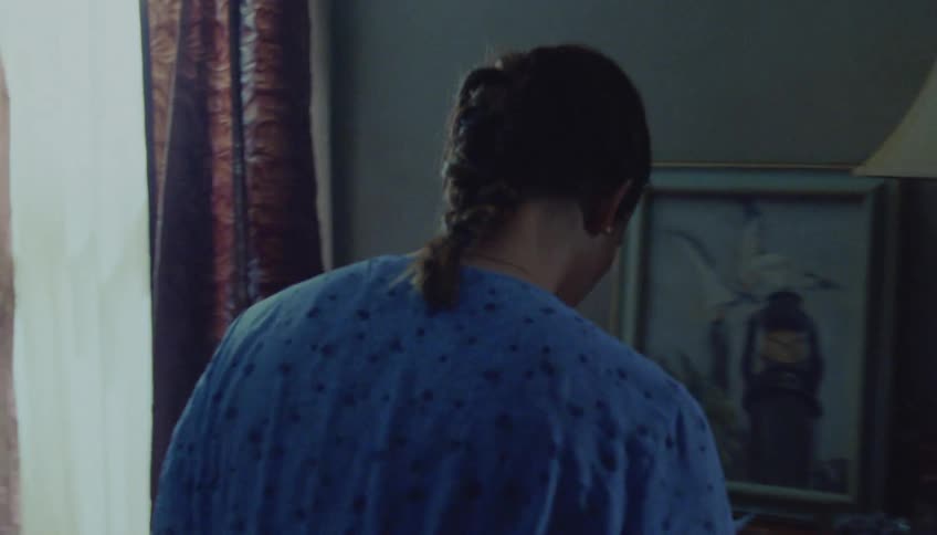 Woman arranging clothes inside an open suitcase on the bed