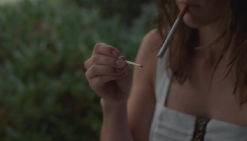 Woman lighting a cigarette outdoors