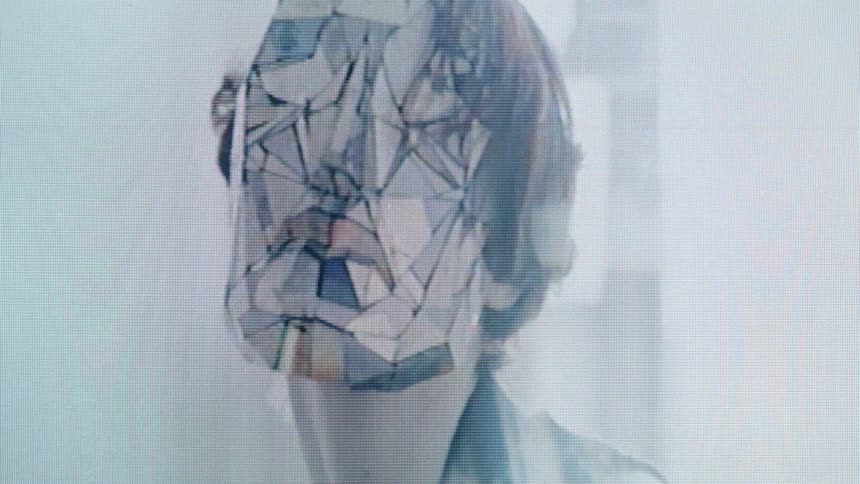 Human face covered by a translucent geometric mask in a lit environment