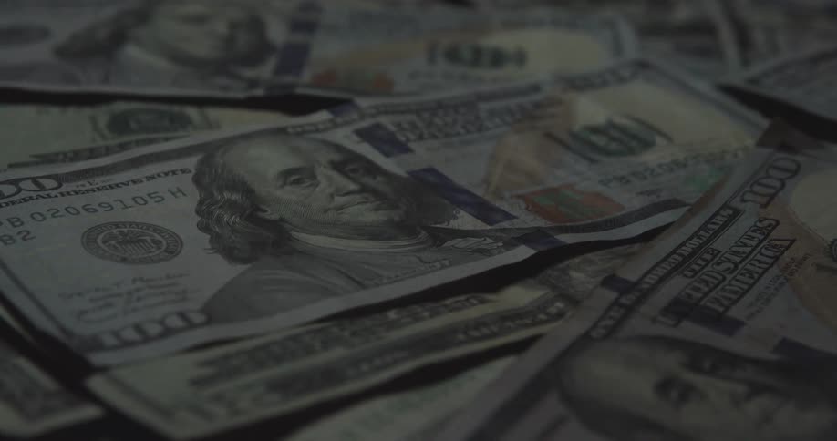 Dollar bills spread over a surface indoors