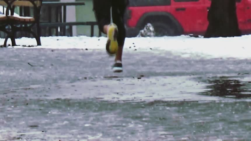 Person running on a wet surface in an urban environment