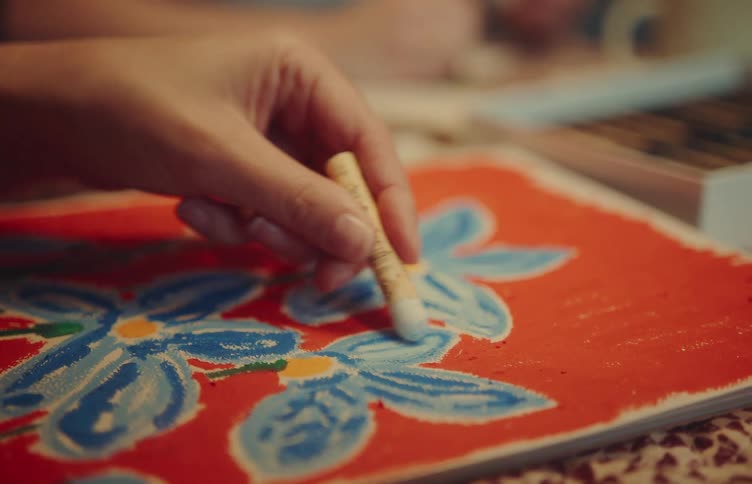 Closeup of a person coloring a blue floral illustration