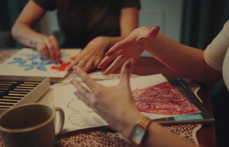 People drawing and painting illustrations on a work table