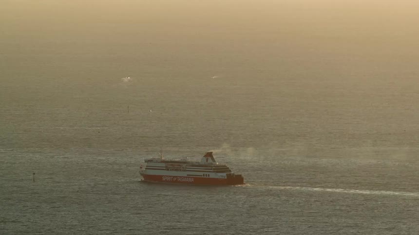 Ferry sailing across the ocean under golden evening light