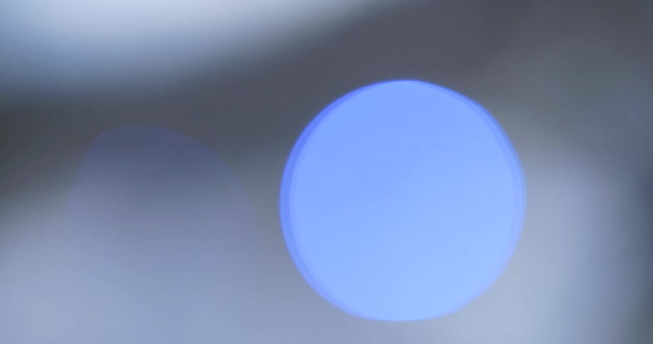 Soft outoffocus lights gently pulse and shift between serene blue and warm orange against a muted blurry backdrop