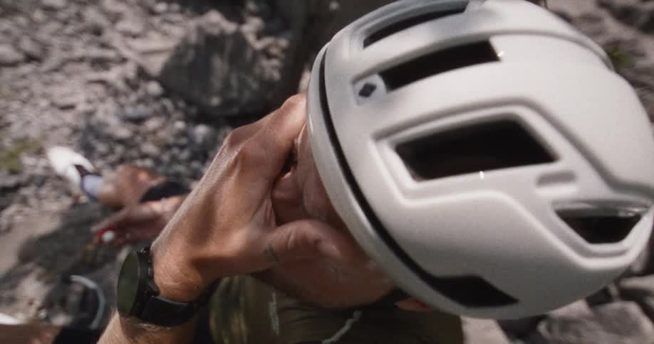 The man is applying sunscreen on his face