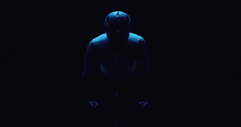 Light shines onto a cyclist pedaling in the dark