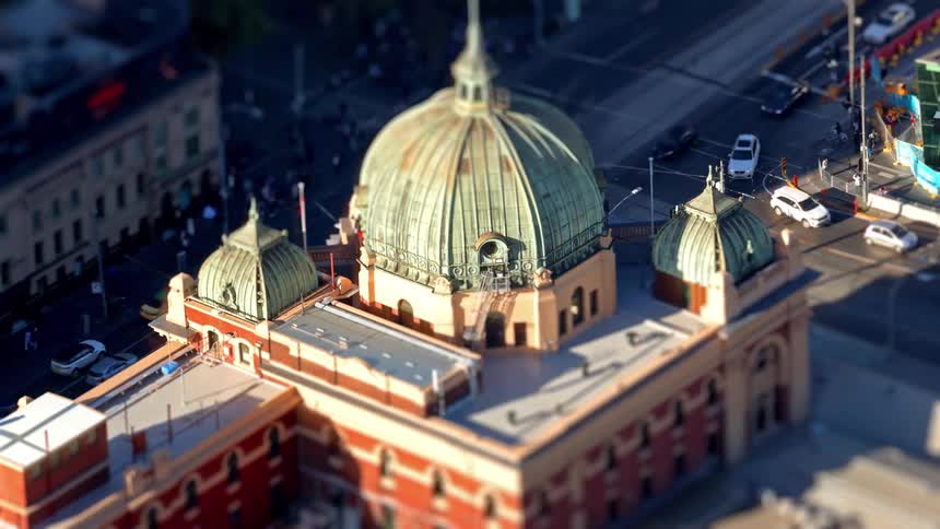 Toy like traffic moves past a grand domed building in the city