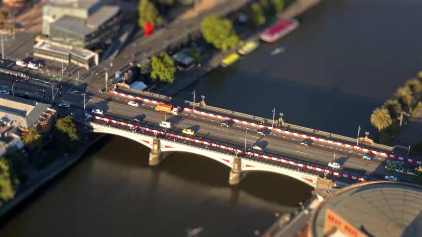 Aerial view of cars and a truck crossing princes bridge over the river in melbourne