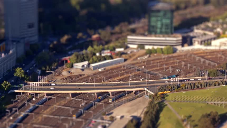 Road overpass above a rail yard with tracks trains and vehicles in an urban area