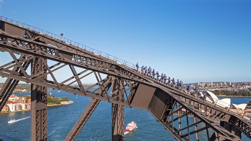A view of people walking on a bridge truss