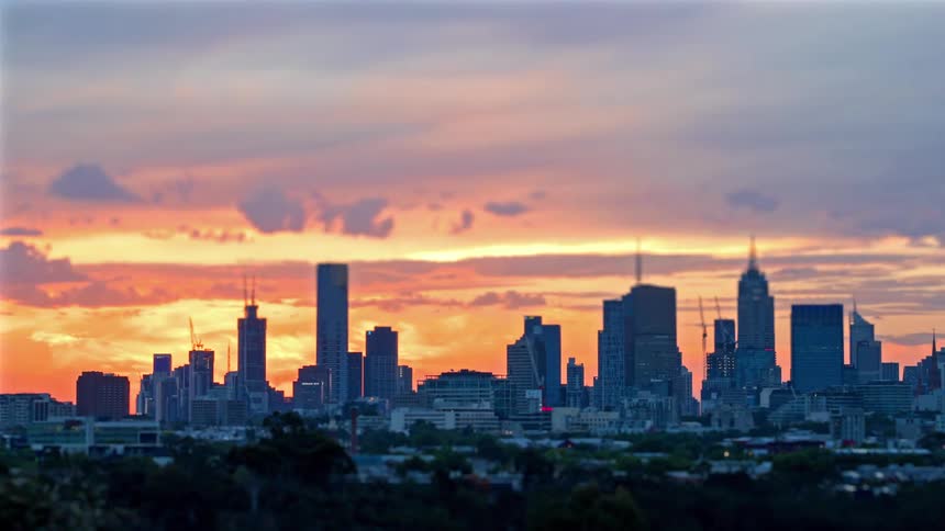 Towers and skyscrapers stand tall on the city skyline as clouds move overhead
