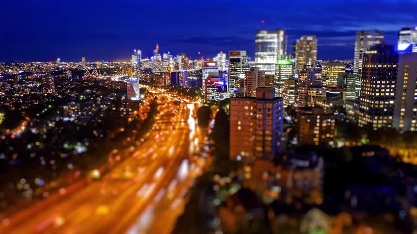 Nighttime view of the urban area with illuminated buildings and a freeway carrying continuous traffic