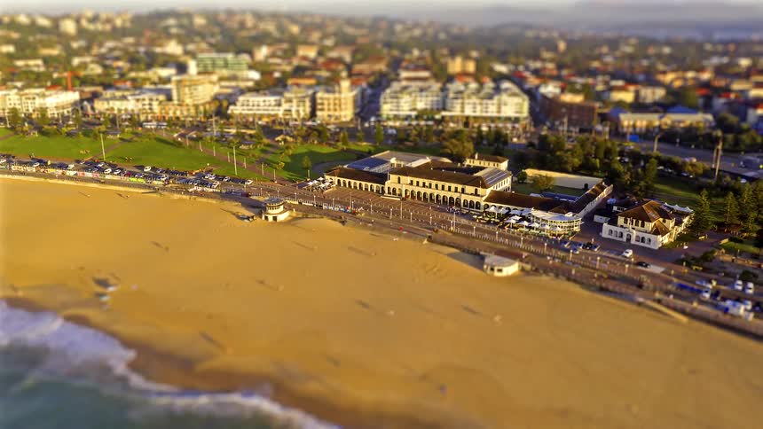 A time lapse of people on a beach near a city