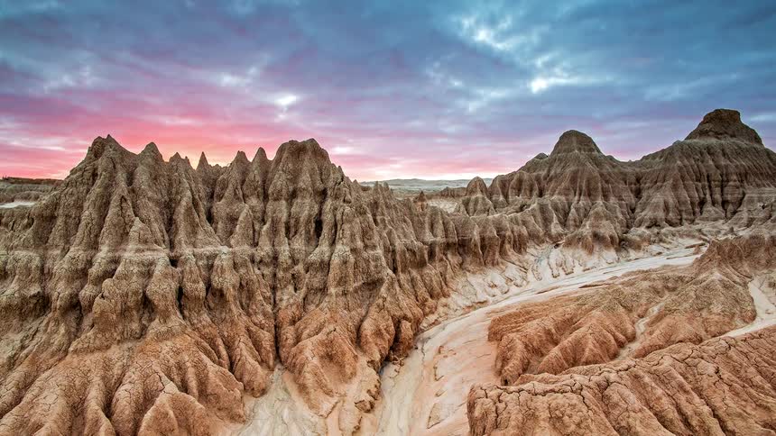 The landscape of badlands national park with a cloudy sky above the natural scenery at midday