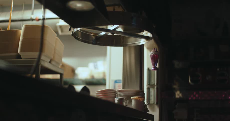 Professional kitchen with stacked plates metal equipment and a preparation area in the background