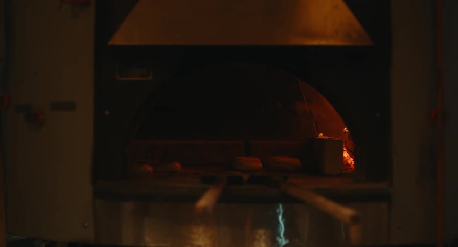 Flames flicker as bread bakes in an oven