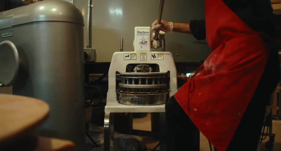 The man is using a machine in the kitchen