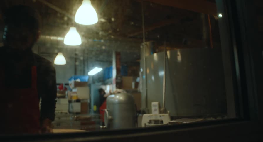Two men are working in a kitchen one man is working near a window