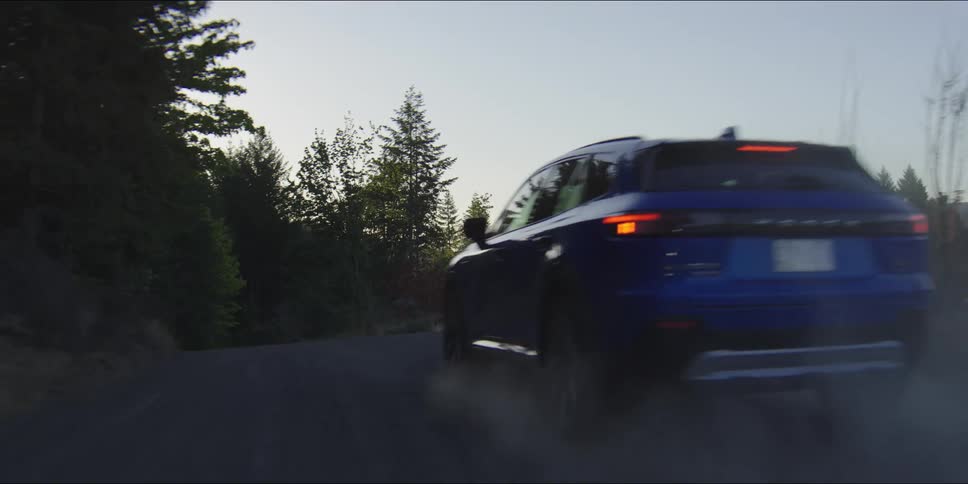 Car traveling on the edge of a forested mountain road