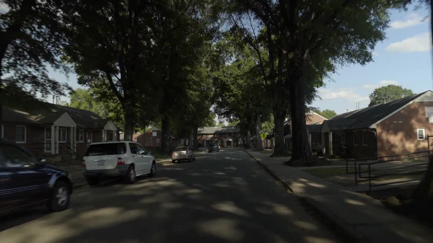 Moving down a residential street with tall trees