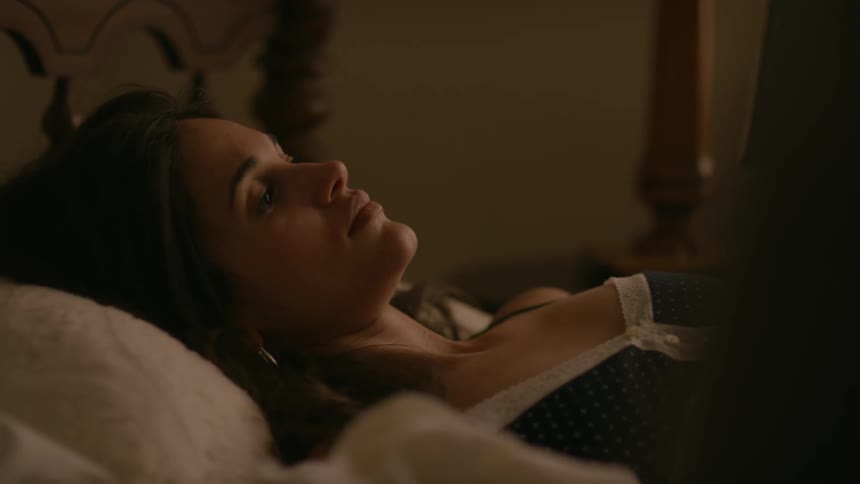 Woman is laying in bed reading a book