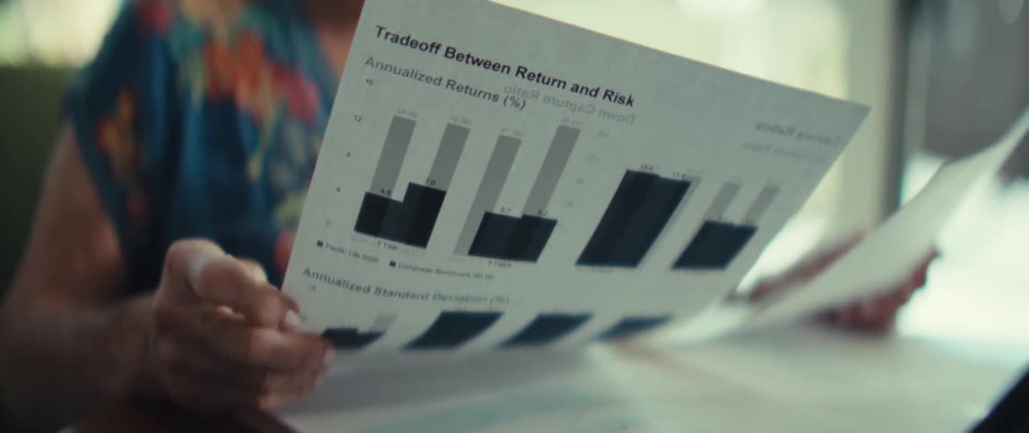 Woman sits at a table looking at financial paperwork