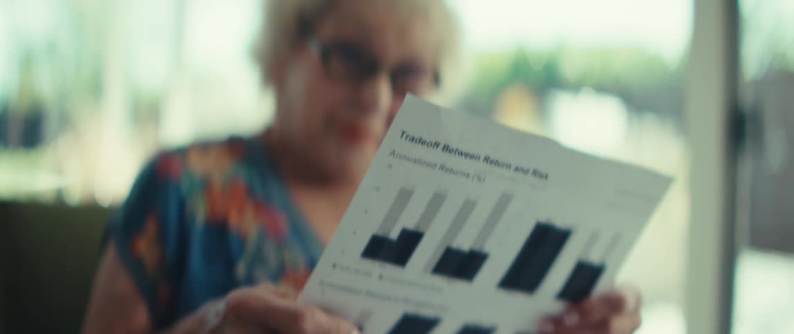 An elderly woman looks at some documents with multiple graphs