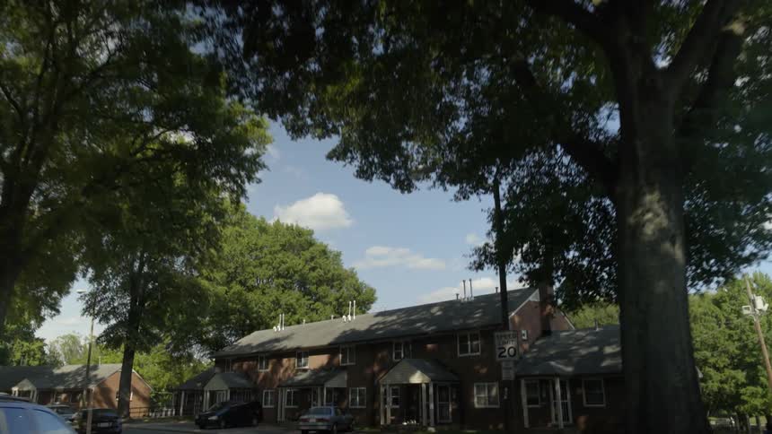 Traveling past trees and houses in neighborhood