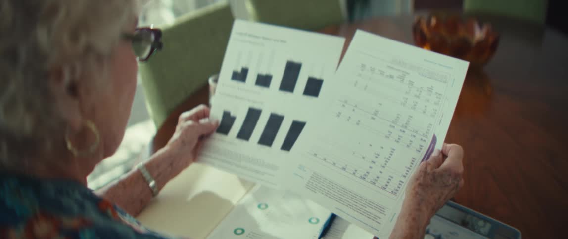 The woman shakes her head while reading paperwork