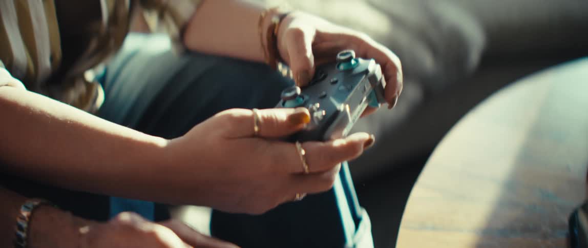 A close up shot captures hands skillfully navigating a video game controller