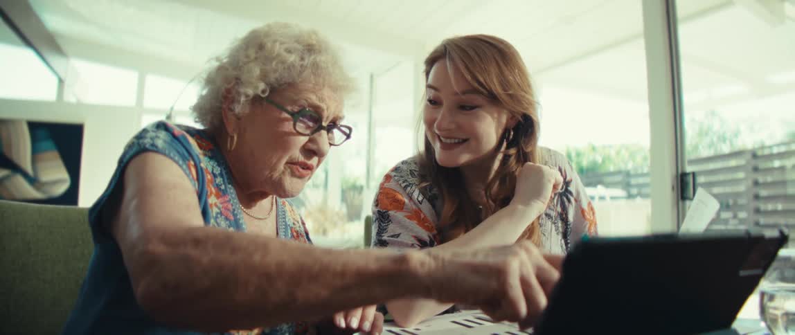 Two women looking at a computer and talking