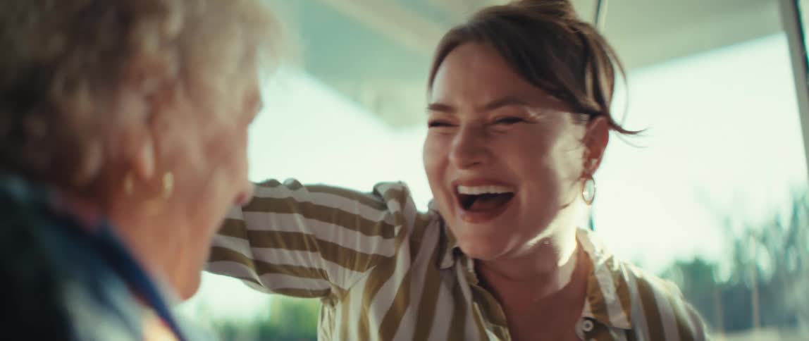 Two women celebrate joyfully while playing video games together