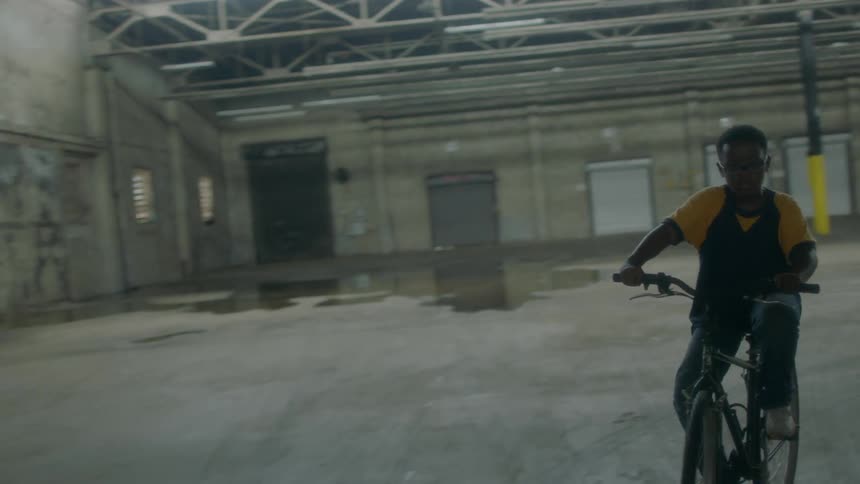 Children ride bikes in an empty warehouse