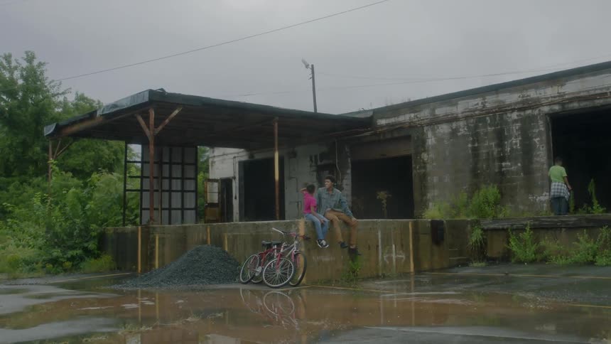 People sit outside an abandoned building