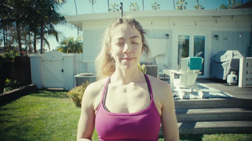 A woman standing outdoors doing yoga