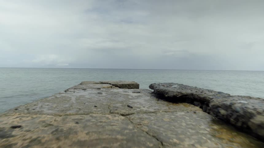 Rocks extend into the ocean on a cloudy day