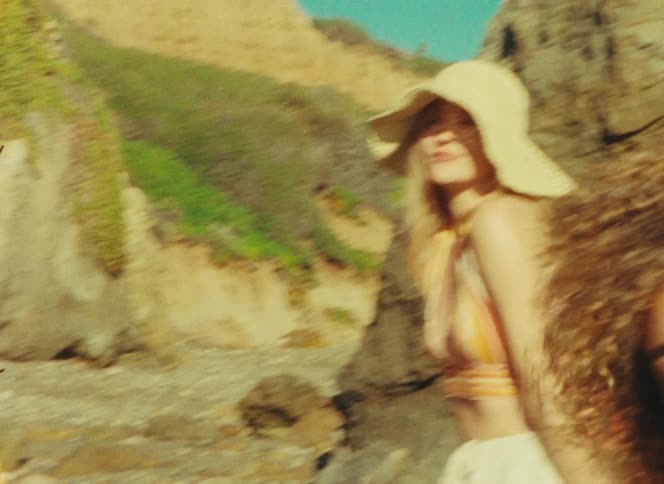 Three diverse women enjoy a sunny day together at a rocky beach