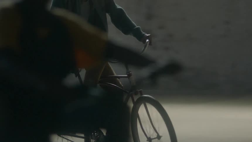 A group of kids ride bikes indoors