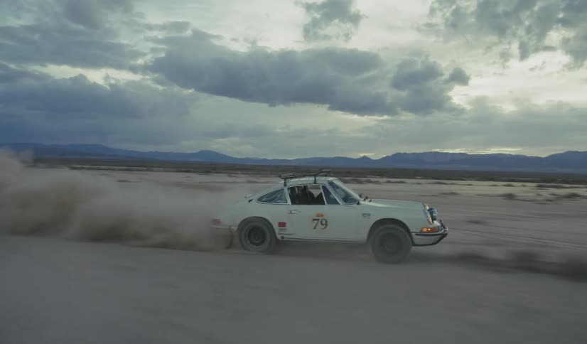 Numbered 79 car moves quickly across a desert plain under cloudy sky