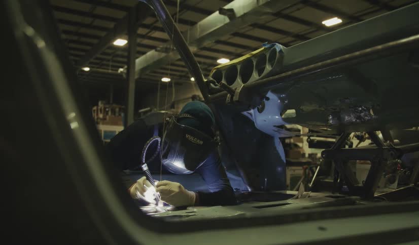 Person wearing a protective mask microwelds in a workshop