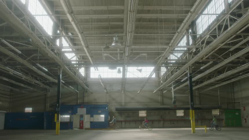 People ride their bicycles in the warehouse
