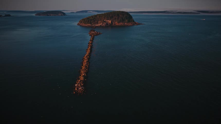 Breakwater leads to one of the islands located near the coast on an overcast day