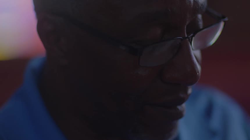 A man with glasses looks down