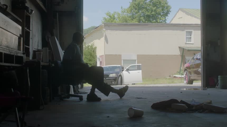 A man sits in a garage