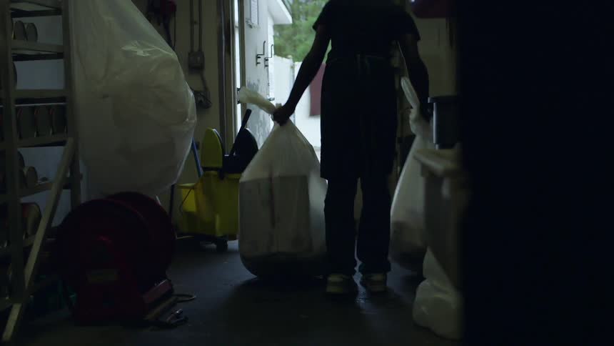 A worker takes out trash bags