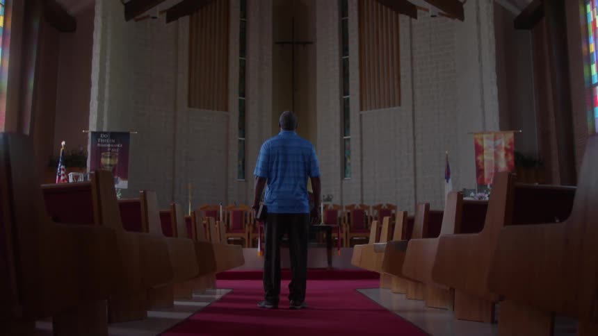 A man sits down on a church pew