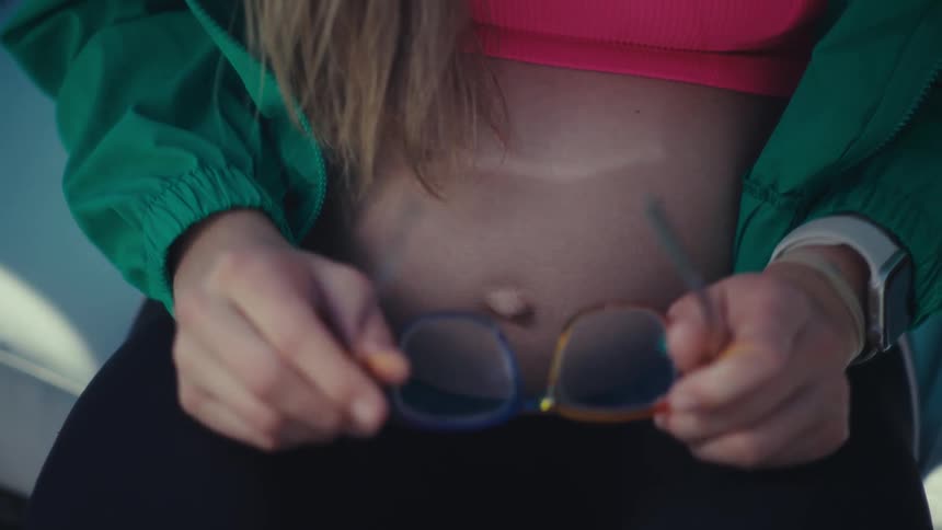 A woman putting on glasses